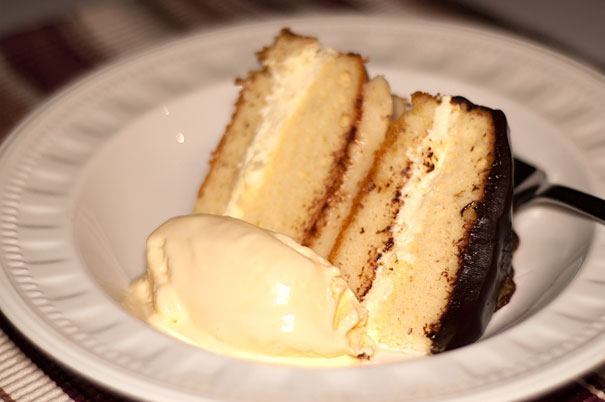 Vanilla Cake filled with Custard and Cream and Covered in Chocolate Ganache